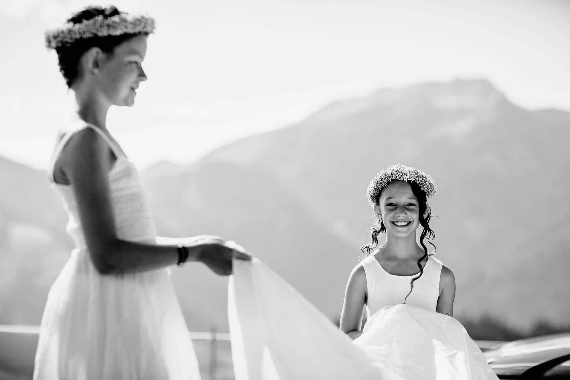Blumenmädchen hilft das Brautkleid tragen und lacht