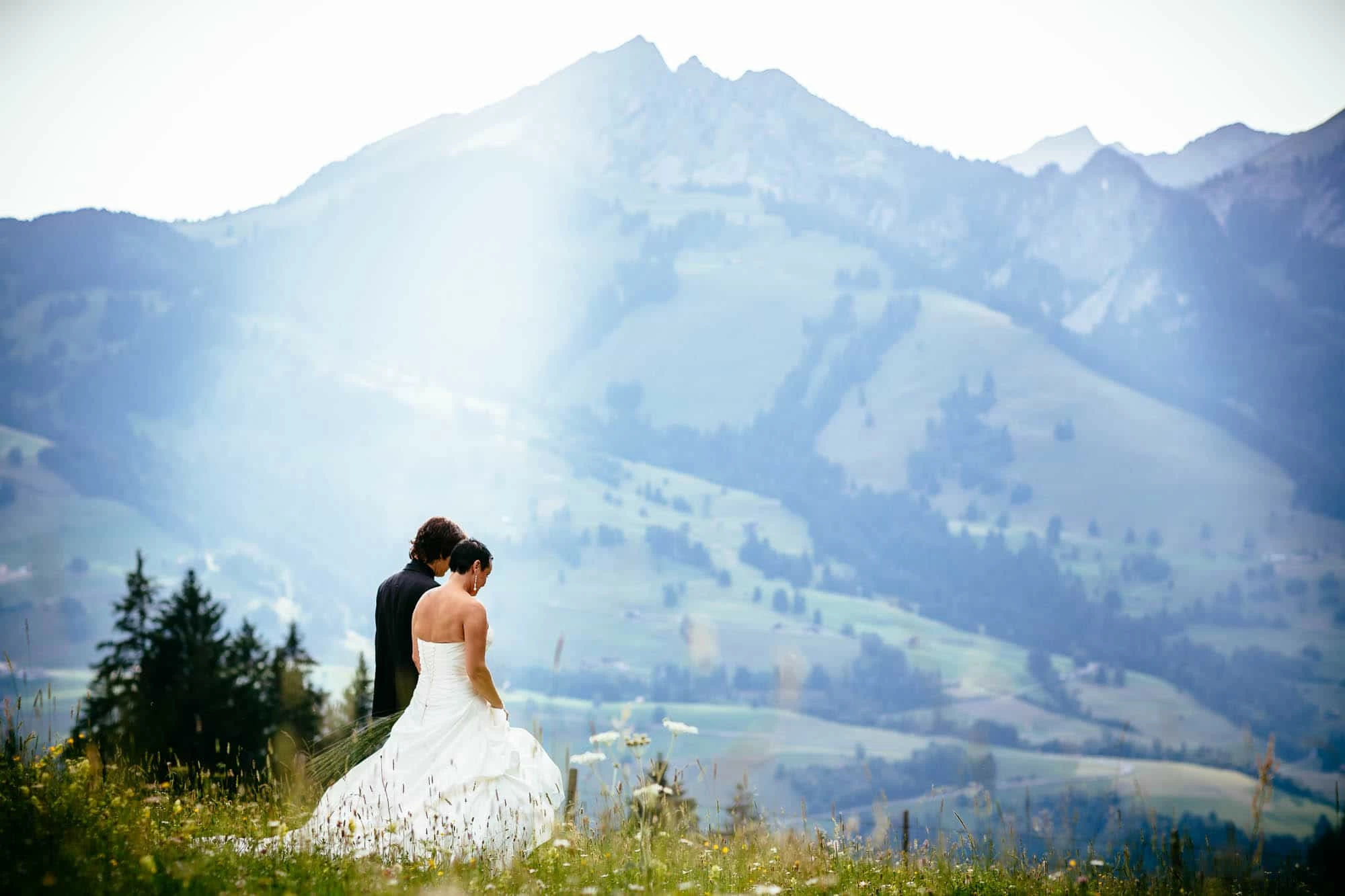 Brautpaarfotos auf einer Alpwiese mit Berg im Hintergrund