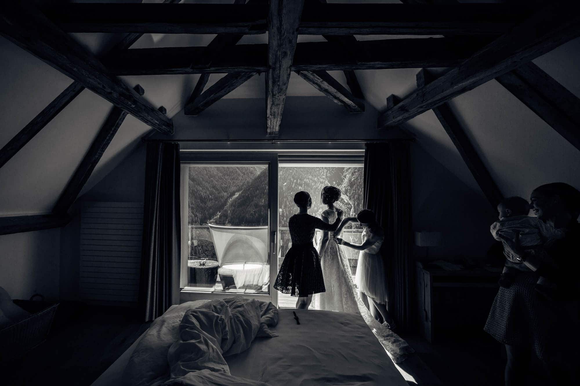 Brautkleid anziehen vor Fenster