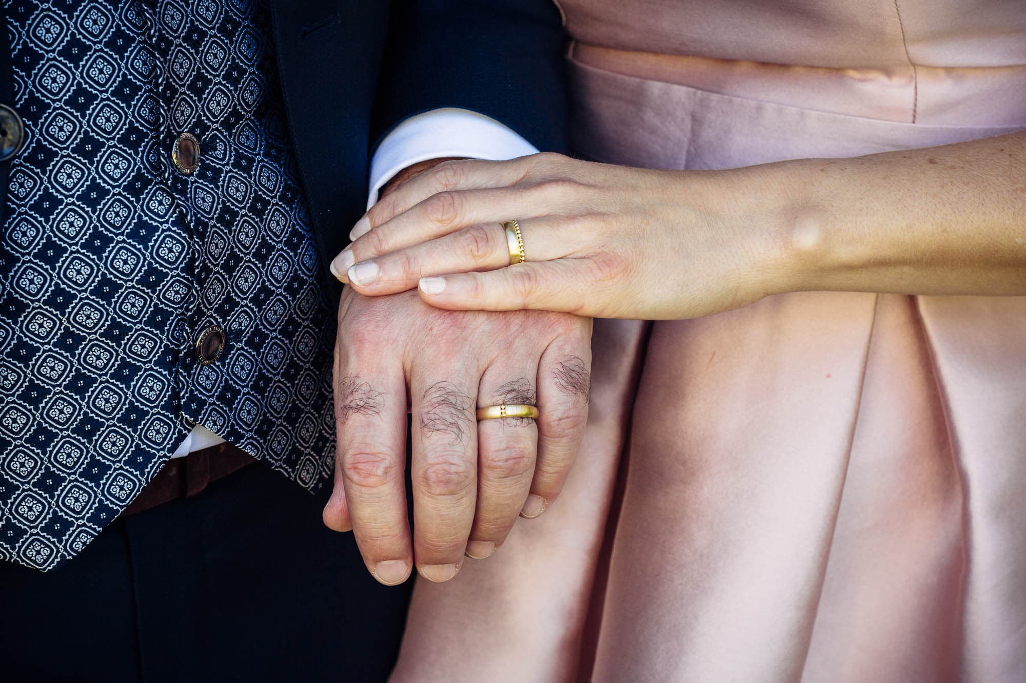 Hände von Braut und Bräutigam mit Ehering