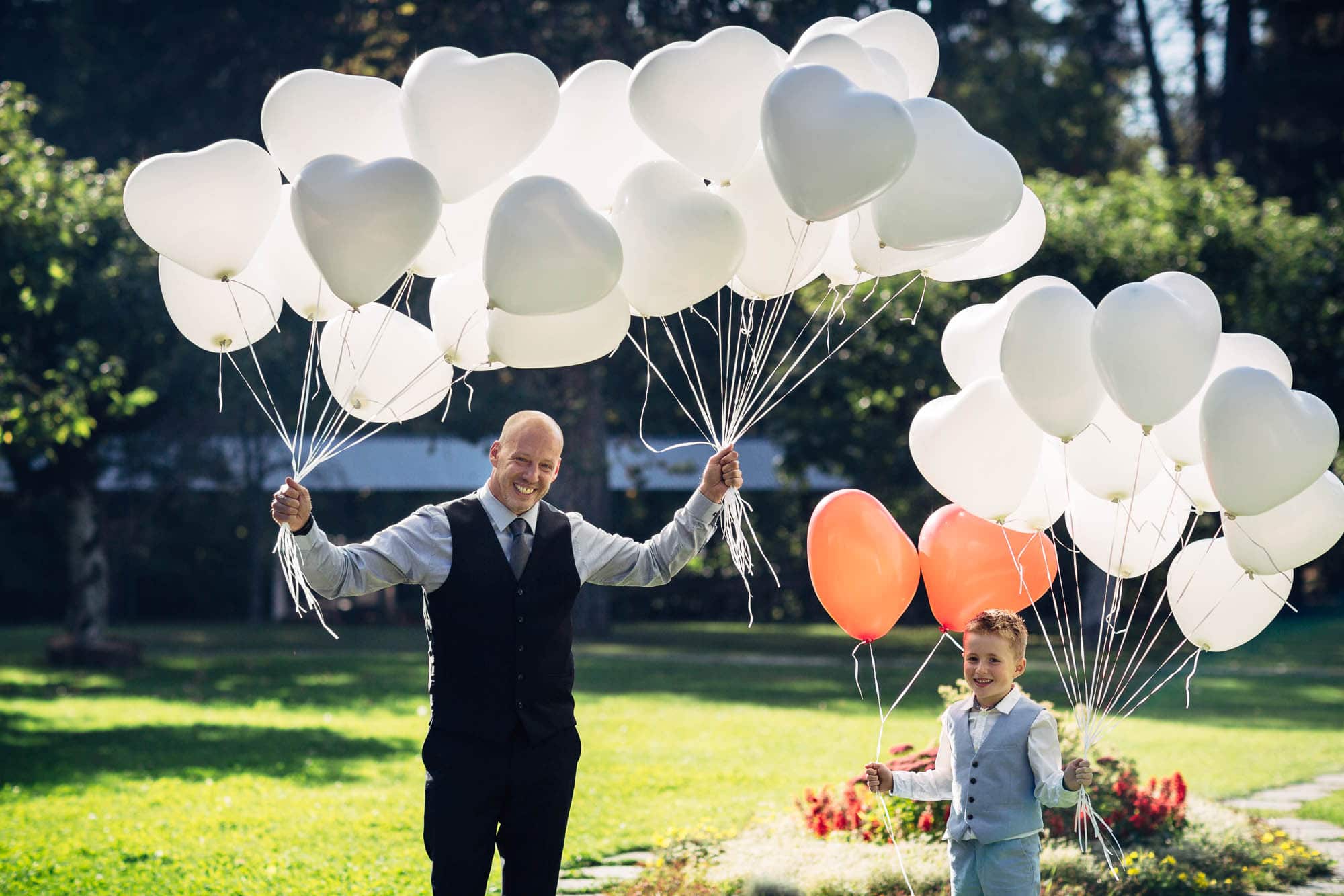 Vater und Sohn halten viele Luftballone