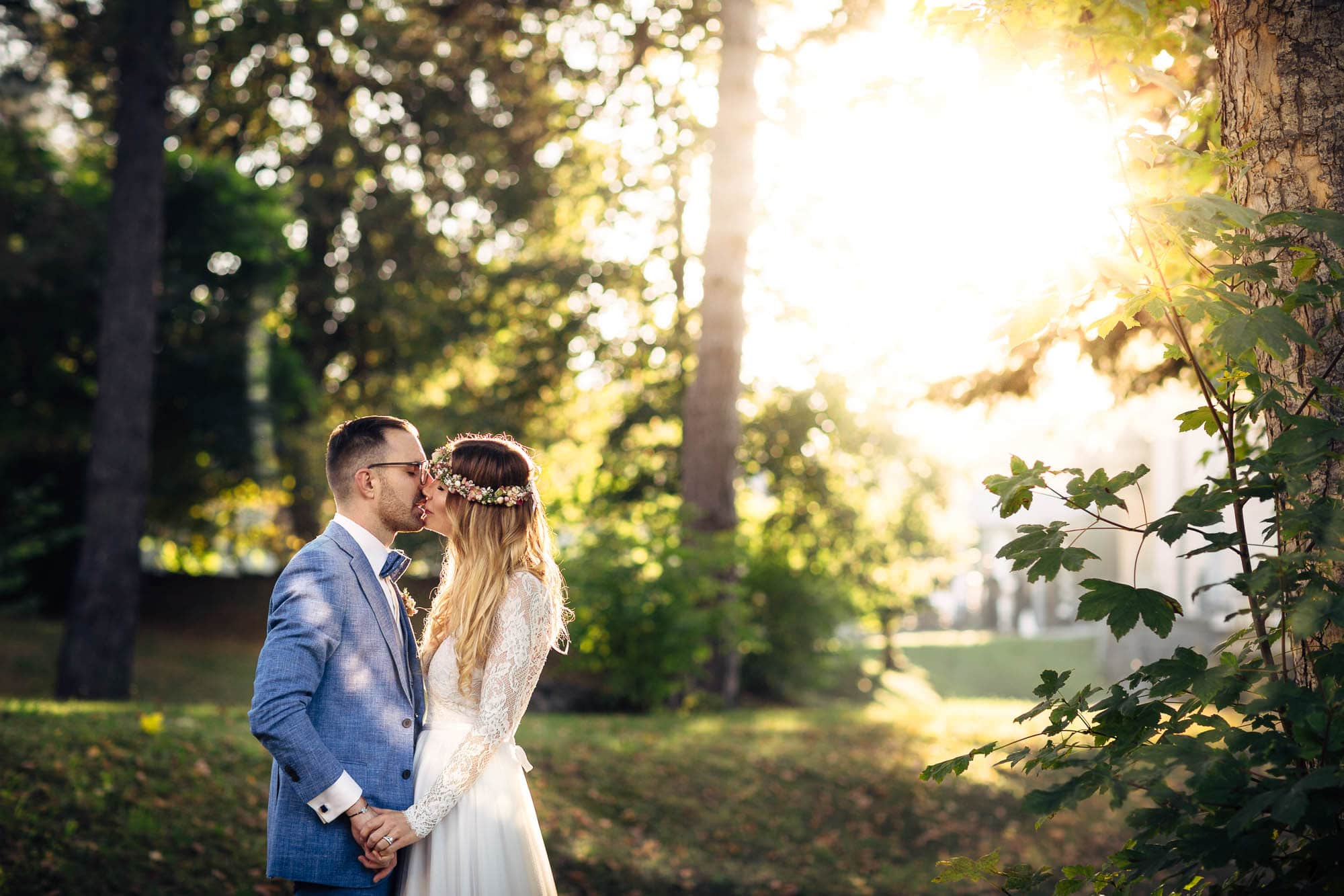 Brautpaar küsst sich im Sonnenschein. Hochzeitsfotograf Flims