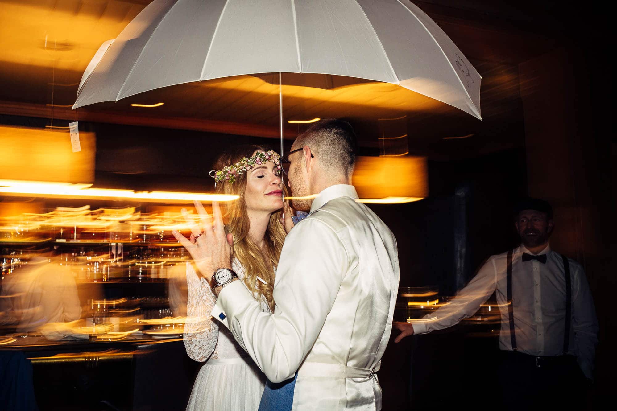 Brautpaar tanzt unter Regenschirm in einer Bar
