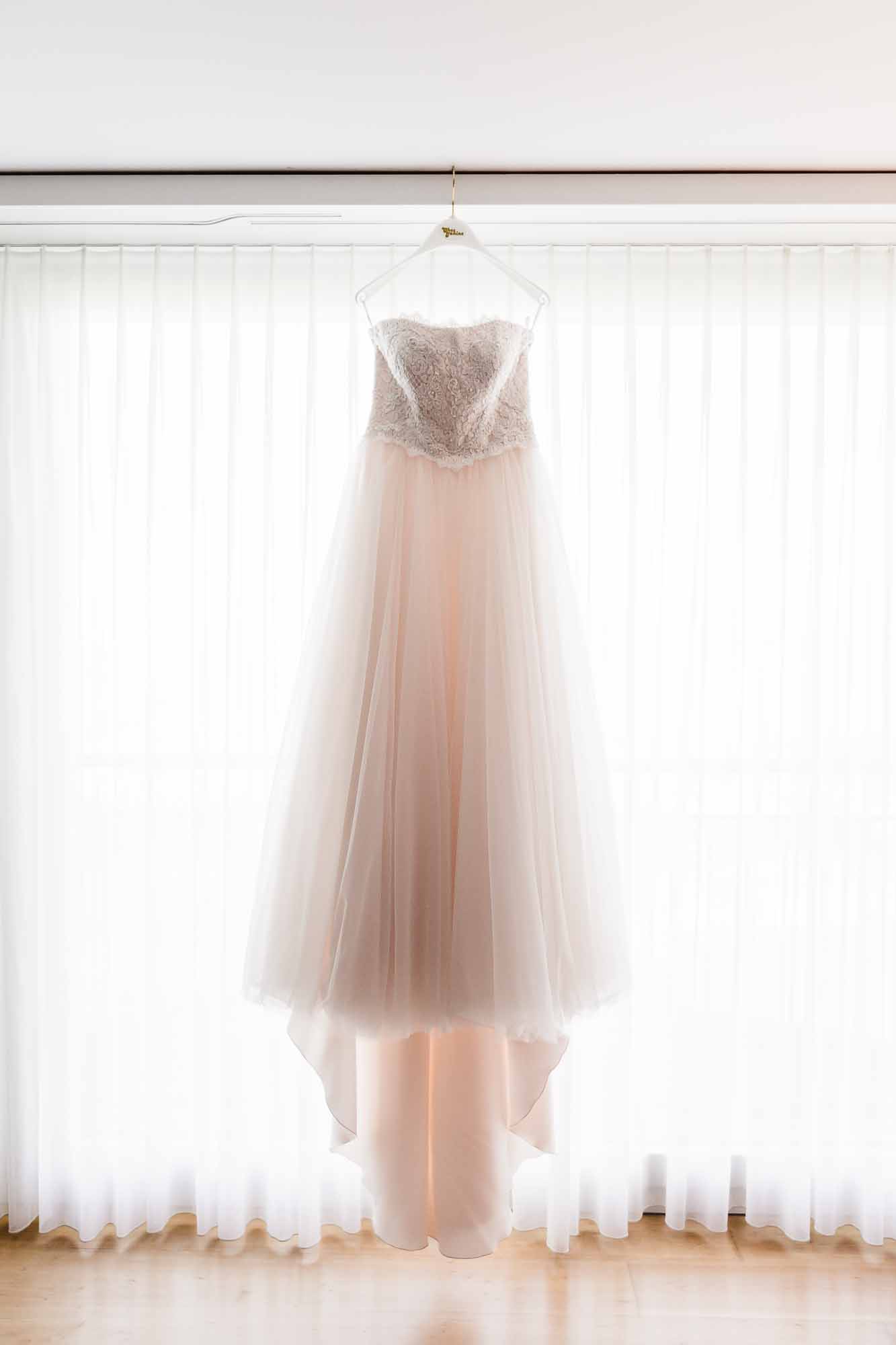 Brautkleid hängt vor Fenster