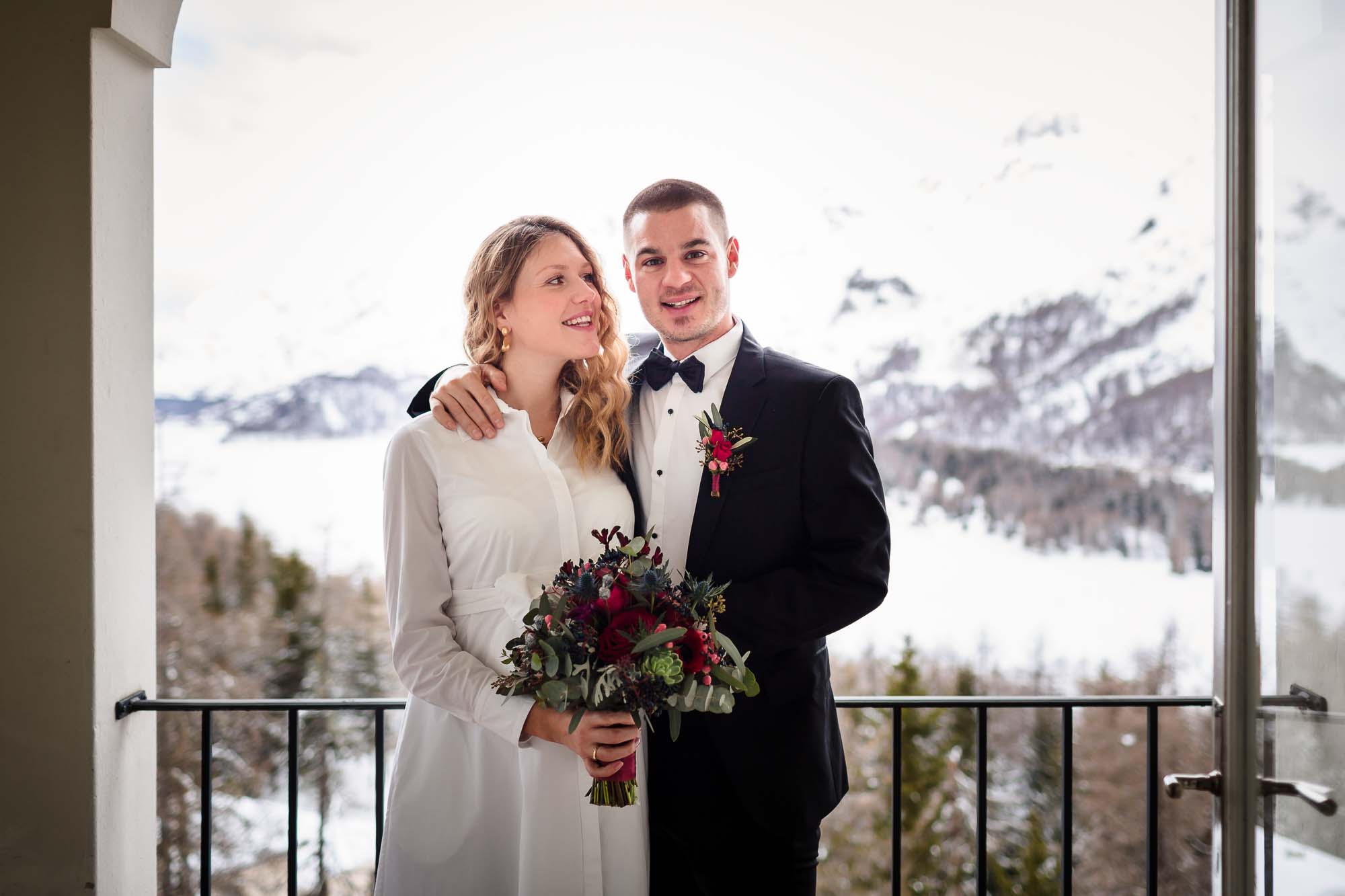 Brautpaar auf Balkon mit Schneebergen im Hintergrund